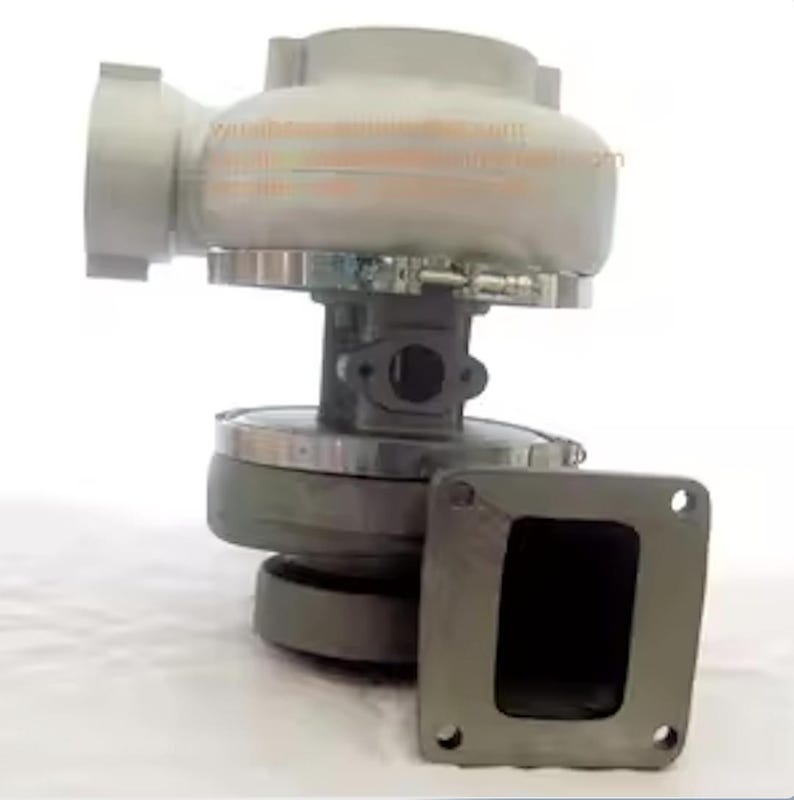 May include: A gray and silver turbocharger with a rectangular flange. The turbocharger has a rounded housing and a circular base. The flange has four mounting holes. The image is against a white background.