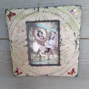 May include: A vintage-style picture frame with a distressed white finish and a floral design. The frame has a glass front and a paper mat. The frame is decorated with butterflies and the text "The happiest one is the one who makes others happy".