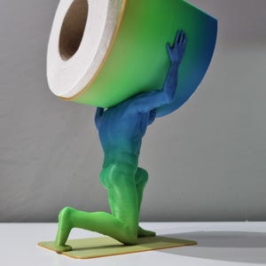 May include: A 3D printed toilet paper holder shaped like a person holding a roll of toilet paper on their back. The person is kneeling and is painted in a gradient of green and blue.
