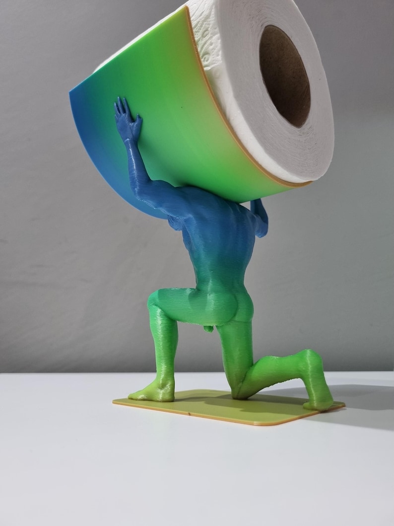 May include: A green, blue, and yellow 3D printed statue of a person holding a roll of toilet paper. The statue is kneeling and the toilet paper is balanced on the person's shoulders.