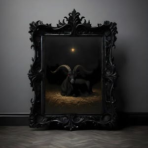 May include: A black framed artwork depicting a black goat with red eyes resting on hay, under a bright star. The frame is elaborately decorated. The artwork is set against a dark background.