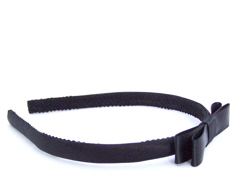 May include: A black headband with a black satin bow.