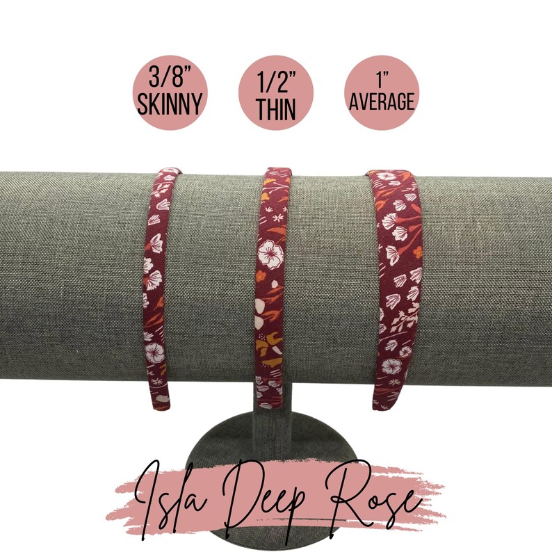 May include: Three red headbands with a floral print in different widths: 3/8 inch skinny, 1/2 inch thin, and 1 inch average. The headbands are displayed on a gray stand. The text "Isla Deep Rose" is written below the stand.