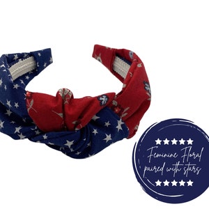 May include: A red and blue headband with a floral pattern and white stars. The headband is knotted in the center and has a white elastic band.