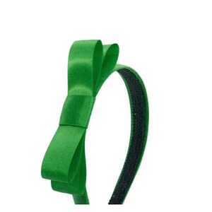 Puede incluir: Una diadema de sat&eacute;n verde con una banda el&aacute;stica negra.