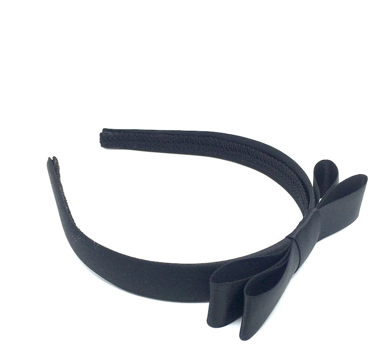 May include: A black satin headband with a large bow. The headband is made of a soft, stretchy material and is perfect for adding a touch of elegance to any outfit.