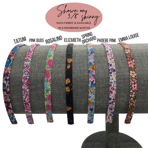 May include: A display of seven fabric headbands in various floral patterns. The headbands are shown on a gray stand. The text on the image says "Shown on 3/8" skinny" and lists the fabric names: Tatum, Pink Buds, Rosalind, Elizabeth, Spring Orchard, Phoebe Pink, and Emma Louise.