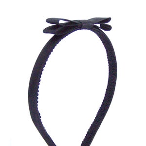 May include: A black headband with a black satin bow.