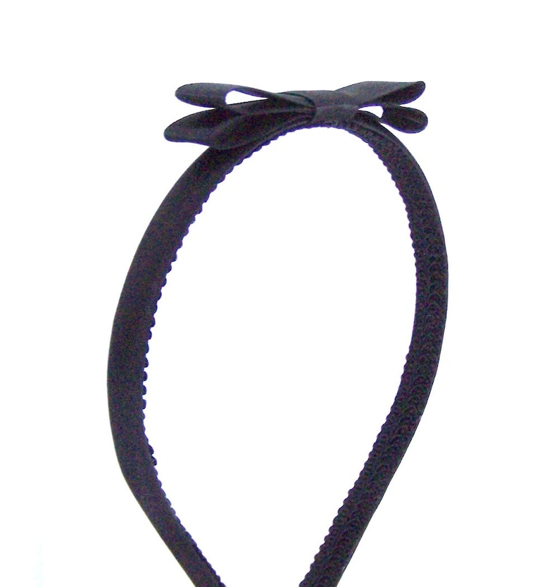 May include: A black headband with a black satin bow.