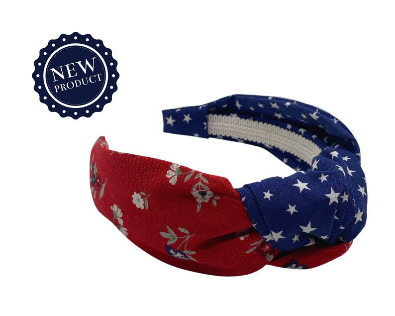 May include: A red and blue knotted headband with a floral pattern on one side and a white star pattern on the other side.