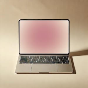 Può includere: Un laptop argentato con una cornice nera e una sfumatura di schermo rosa. La tastiera ha un layout standard con un touchpad sottostante. Il laptop è su uno sfondo neutro, con un'ombra proiettata a destra.