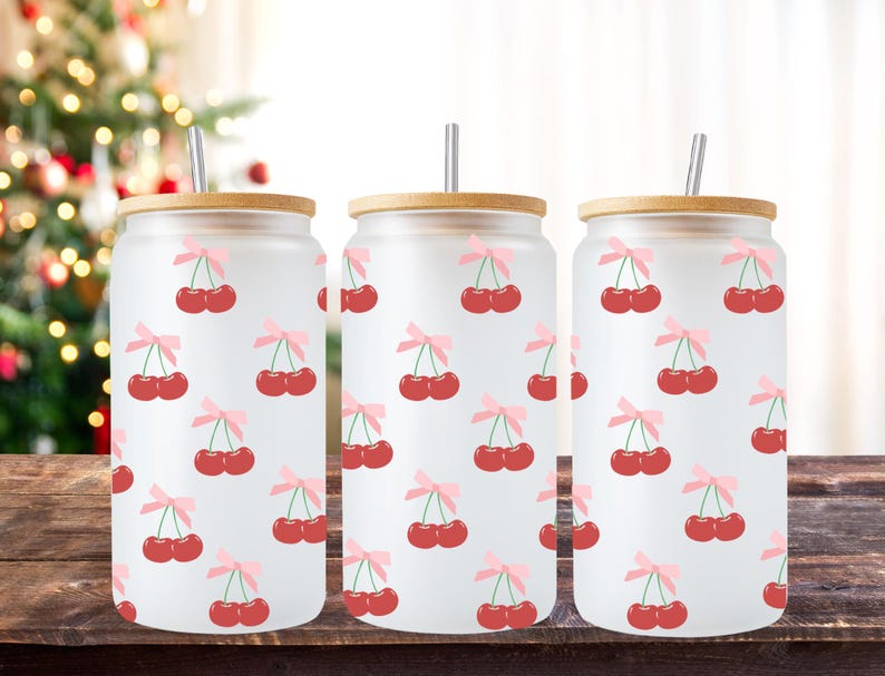 May include: Three frosted glass tumblers with bamboo lids and stainless steel straws. Each tumbler features a repeating pattern of red cherries with pink bows on a white background.