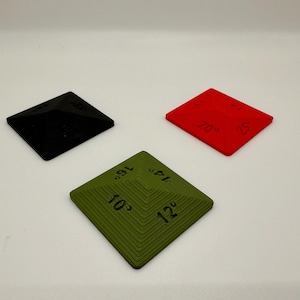 May include: Three pyramid-shaped dice with different colored surfaces. The dice are black, red, and green. The numbers on the dice are 10, 12, 14, 16, 18, 20, 25.