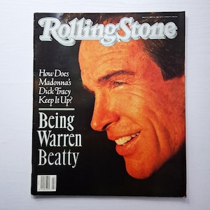 May include: Rolling Stone magazine cover featuring a portrait of Warren Beatty. The cover has the magazine's logo at the top and text that reads "How Does Madonna's Dick Tracy Keep It Up? Being Warren Beatty."