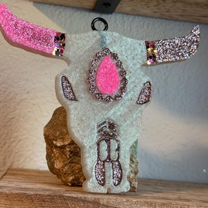 May include: White glitter bull skull ornament with pink glitter horns and a pink glitter eye.