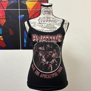May include: Black tank top with thin straps featuring the band name "AVATAR" in red and white lettering. Below the band name is a graphic of the band members. The text "HAIL THE APOCALYPSE TOUR" is printed in a circle around the graphic.