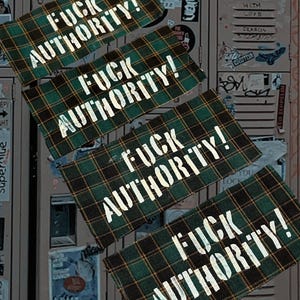 May include: Four green and black plaid patches with the words "FUCK AUTHORITY!" in white block letters. The patches are arranged diagonally against a background of a locker door covered in stickers.
