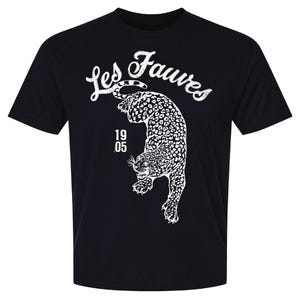 May include: A black short-sleeve t-shirt featuring a white graphic of a leopard in a pouncing position. Above the leopard, the text Les Fauves is printed in a distressed white font. To the left of the leopard, the numbers 19 and 05 are stacked.