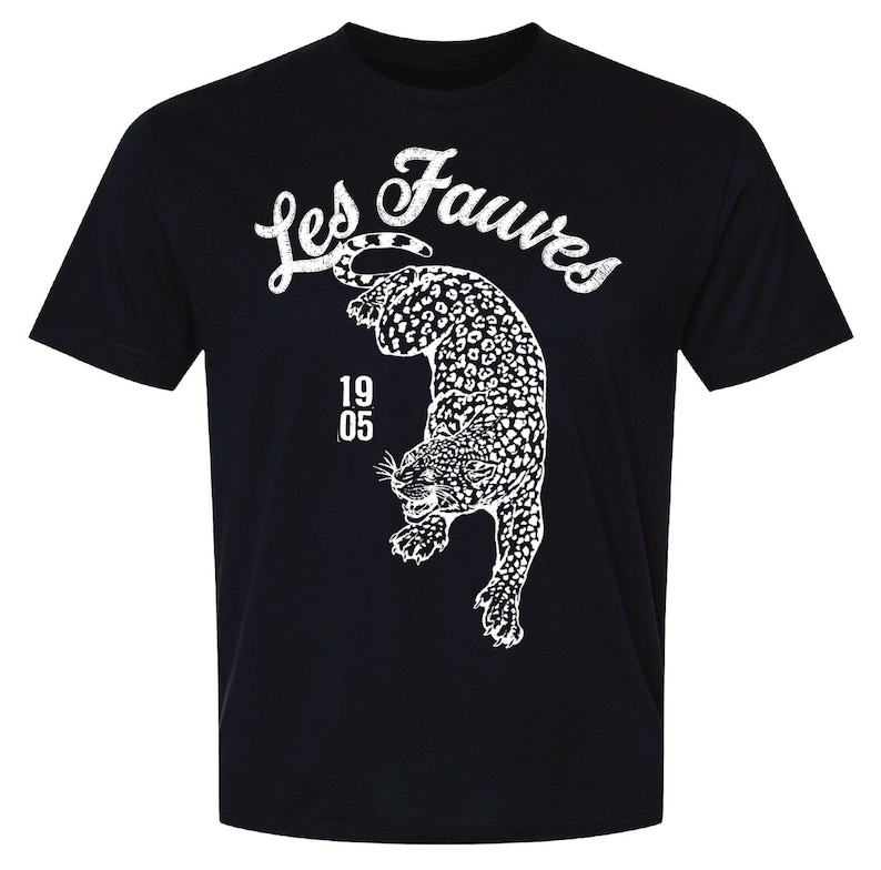 May include: A black short-sleeve t-shirt featuring a white graphic of a leopard in a pouncing position. Above the leopard, the text Les Fauves is printed in a distressed white font. To the left of the leopard, the numbers 19 and 05 are stacked.