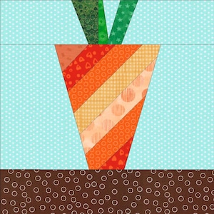 May include: A colorful patchwork carrot design. The carrot features orange and red diagonal stripes with various patterns. Green and brown fabric represent the carrot top and soil. The background is light blue with white polka dots.