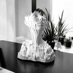 May include: White ceramic sculpture of a human bust with a melted, dripping effect. The sculpture is a modern art piece with a unique design.