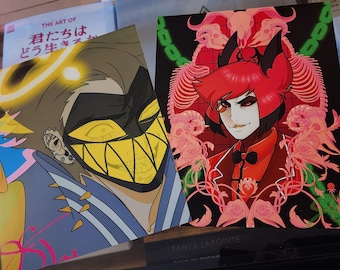 May include: Two colorful art prints featuring stylized characters. One print showcases a character with a yellow-toothed grin and a mask. The other depicts a character in a red suit with a black background and floral accents. The prints are likely from a comic or animated series.