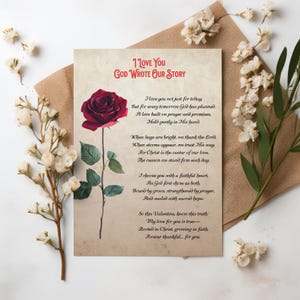 May include: A greeting card with the text "I Love You God Wrote Our Story" and a poem. The card features a large, dark red rose with green leaves. The card is on a brown envelope, with white flowers and greenery.