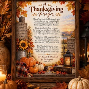 May include: A framed wall art piece featuring the text A Thanksgiving Prayer, surrounded by autumn imagery including orange pumpkins, colorful fall leaves, a sunflower, a lantern, and a Bible. The background depicts a sunset over a rural landscape.