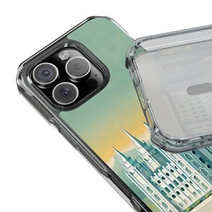 May include: Clear protective phone case with a scenic design. The case features a detailed illustration of a white building with spires against a backdrop of a yellow and green sky. The case has a clear, transparent bumper.