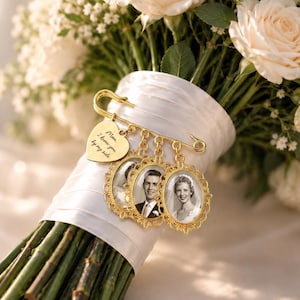 Puede incluir: Un broche de imperdible dorado sujeto a un ramo envuelto en satén blanco. El broche presenta un dije en forma de corazón grabado con el texto "Mom, I know you by my side" y tres marcos ovalados de filigrana con fotos en blanco y negro.
