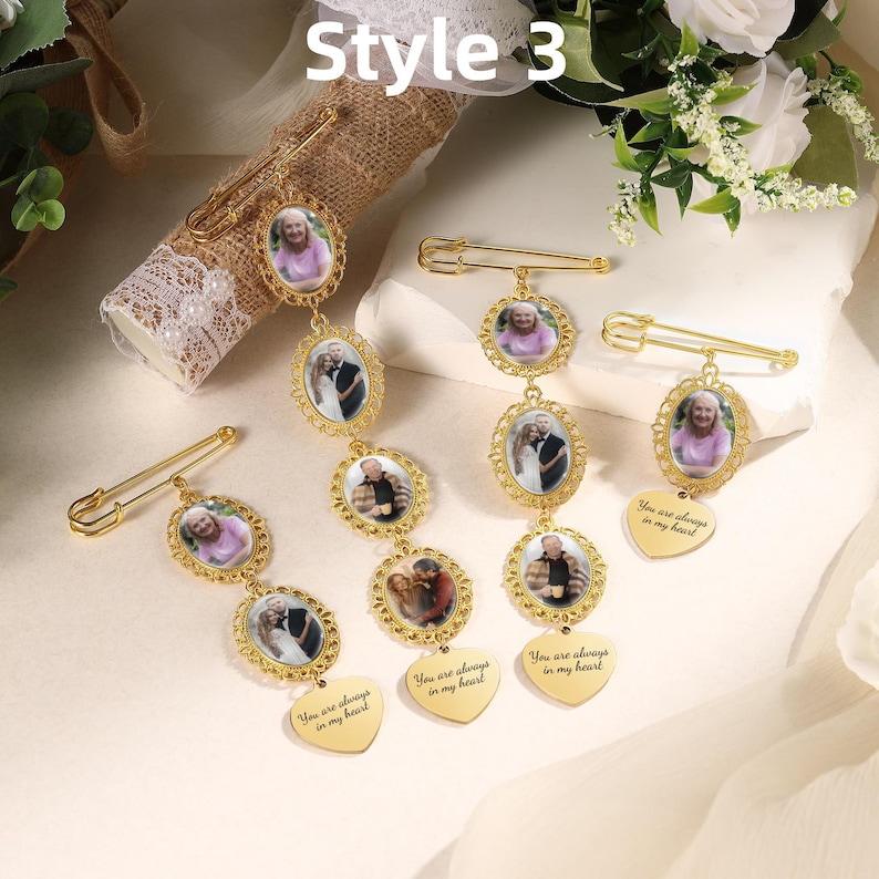 May include: Four gold-toned metal brooch pins featuring oval frames with inset photographs of people. Each pin includes a dangling heart-shaped charm engraved with the text 'You are always in my heart'. The pins vary in length with one to three photo frames.