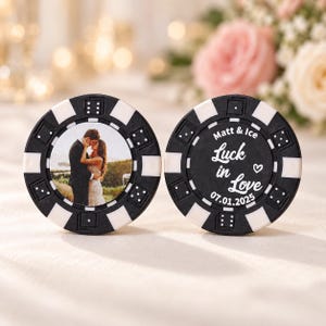 May include: Two round black and white poker chips. One chip features a photograph of a couple embracing outdoors. The other chip displays the text Matt & Ice, Luck in Love, a heart icon, and the date 07.01.2025 printed in white on a black background.