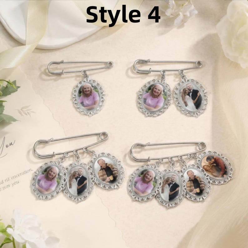 May include: Four silver-toned safety pins featuring oval-shaped photo charms. The pins display varying numbers of dangling frames, each containing a small color photograph of individuals or couples. The frames have a decorative, scalloped edge.