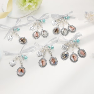 May include: A collection of six memorial photo charms featuring oval silver-toned frames, white faux pearl beads, and light blue accent beads. Each charm includes a white ribbon bow and a heart-shaped metal tag engraved with the text You are always in my heart.