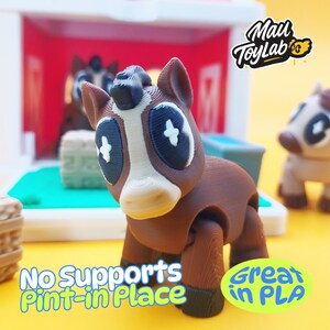 May include: A brown and white 3D-printed toy horse with large eyes and a stylized design. The toy is part of a set, with a second horse visible in the background. Text on the image reads "No Supports Pint-in Place" and "Great in PLA".