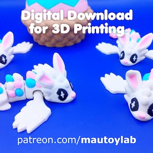 Puede incluir: Juguetes articulados con forma de conejito blanco, impresos en 3D, con alas y detalles en colores pastel, sobre un fondo azul. El texto dice "Digital Download for 3D Printing" y "patreon.com/mautoylab".