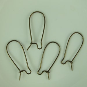 May include: Four gold-toned earring hooks, each with a simple, rounded shape. The hooks are made of metal and have a smooth finish.