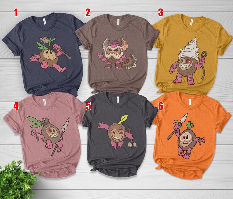 Puede incluir: Seis camisetas de manga corta en varios colores, cada una con un dise&ntilde;o de personaje de dibujos animados. Los personajes tienen una apariencia de coco con diferentes expresiones y accesorios. Las camisetas son azul marino, marr&oacute;n, amarillo mostaza, rosa polvoriento, carb&oacute;n y naranja.