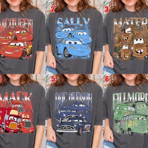 May include: Six gray t-shirts featuring characters from the movie Cars. Each shirt has a different design, including McQueen, Sally, Mater, Mack, Doc Hudson, and Fillmore, in a vintage style.