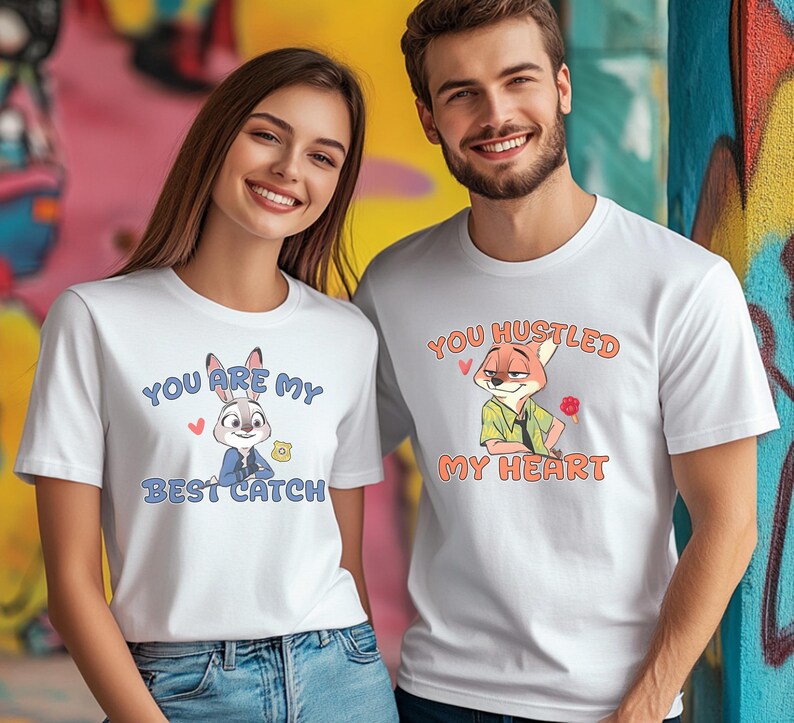 May include: Two white short-sleeved t-shirts featuring cartoon characters. The left shirt displays a rabbit with the text "YOU ARE MY BEST CATCH". The right shirt displays a fox with the text "YOU HUSTLED MY HEART" and a small red paw print.