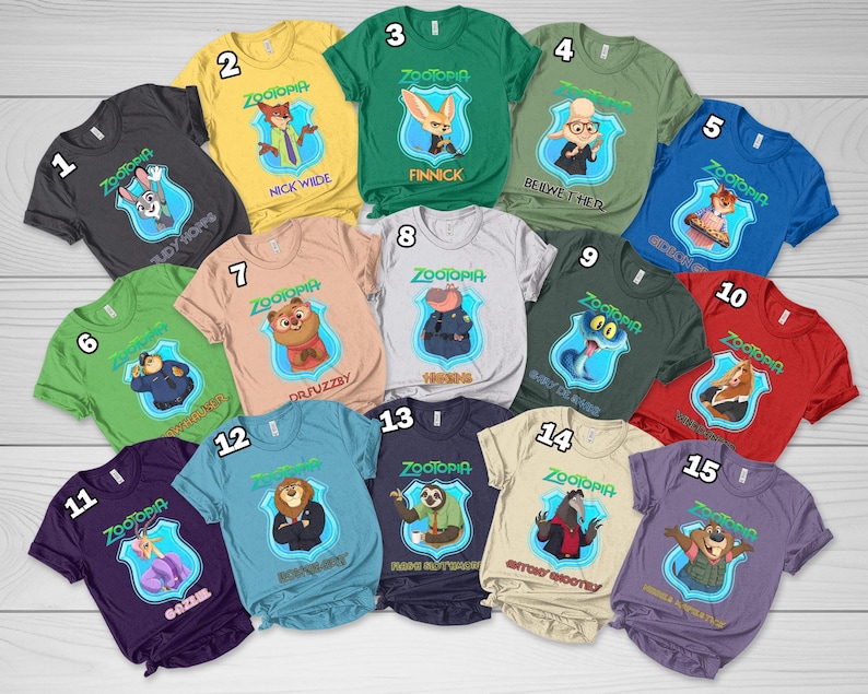 Op de afbeelding: Een collectie van vijftien t-shirts met korte mouwen in diverse kleuren, elk voorzien van een Zootopia-personage in een blauw schildembleem met de tekst Zootopia en de naam van het personage eronder gedrukt, genummerd van &eacute;&eacute;n tot vijftien.