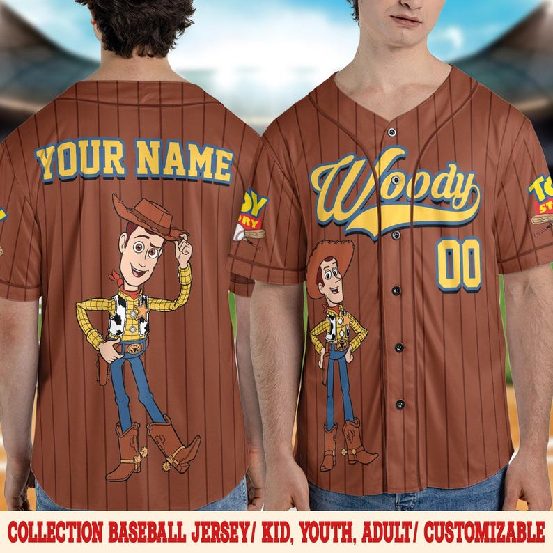 Puede incluir: Camiseta de b&eacute;isbol marr&oacute;n con un dise&ntilde;o de dibujos animados de Woody. La camiseta tiene rayas verticales, el nombre "Woody" en escritura amarilla y el n&uacute;mero "00". La parte posterior de la camiseta dice "YOUR NAME".