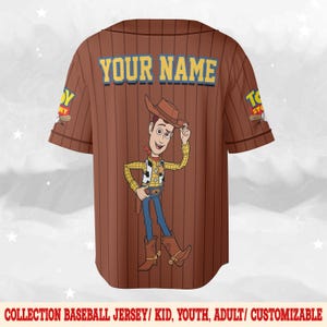 Puede incluir: Camiseta de b&eacute;isbol marr&oacute;n con una imagen de dibujos animados de Woody de Toy Story. La camiseta tiene rayas verticales, el texto "YOUR NAME" en la parte superior de la espalda y el logotipo de Toy Story en las mangas. La parte inferior de la camiseta dice "COLLECTION BASEBALL JERSEY/ KID, YOUTH, ADULT/ CUSTOMIZABLE".