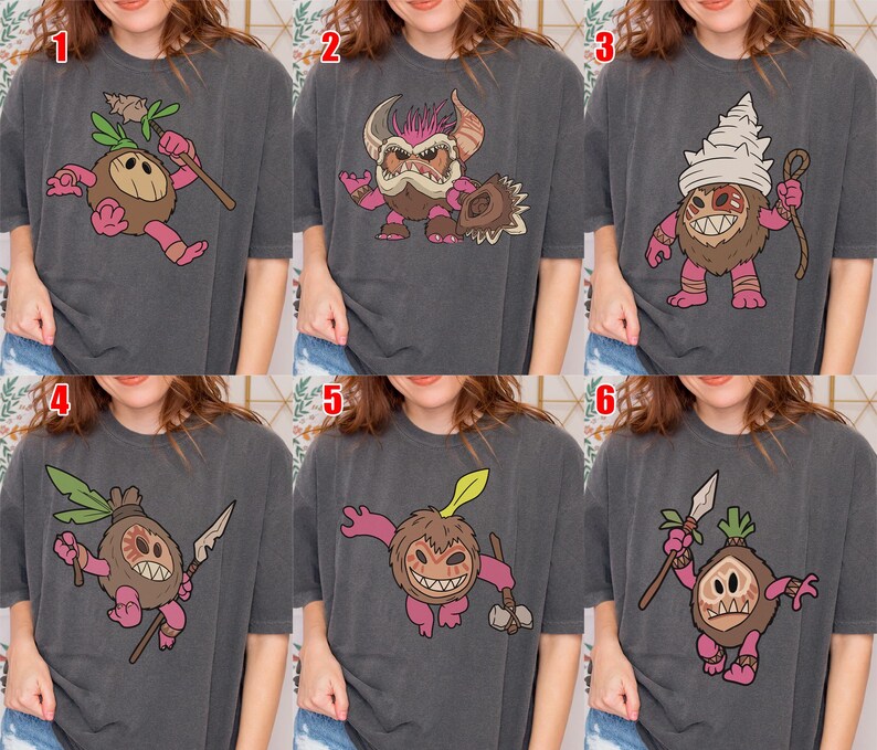 Puede incluir: Seis camisetas de color gris antracita con diferentes dise&ntilde;os de monstruos de dibujos animados. Cada monstruo tiene un cuerpo marr&oacute;n, extremidades rosas y varios accesorios como lanzas, garrotes y tocados. Los dise&ntilde;os est&aacute;n centrados en las camisetas.