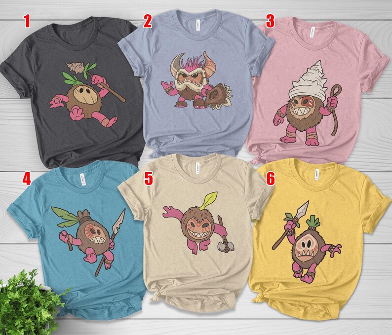 Puede incluir: Una colecci&oacute;n de seis camisetas de varios colores, cada una con un dise&ntilde;o de personaje de dibujos animados. Los dise&ntilde;os representan una criatura parecida a un coco con diferentes accesorios y expresiones. Las camisetas son en tonos de gris, azul, rosa y amarillo.
