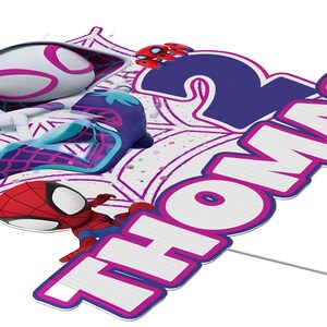 A colorful and vibrant Spider-Man-themed birthday cake topper with the name "Thomas" written on it.