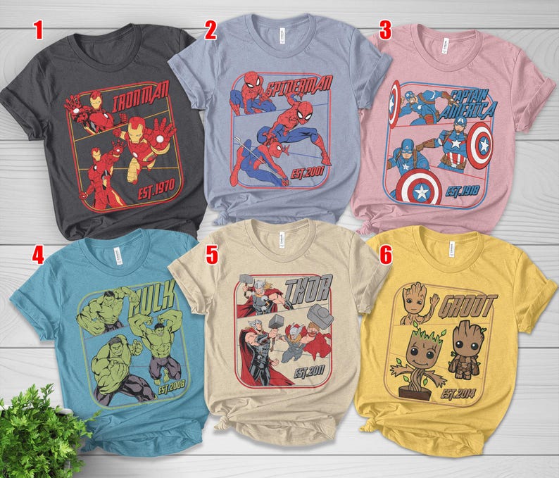 K&ouml;nnte beinhalten: Sechs kurz&auml;rmelige T-Shirts mit Marvel-Comicfiguren. Die Shirts sind in verschiedenen Farben erh&auml;ltlich, darunter Grau, Blau, Rosa und Gelb. Jedes Shirt hat eine andere Charaktergrafik, wie Iron Man, Spider-Man, Captain America, Hulk, Thor und Groot.