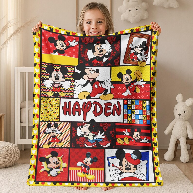 Pu&ograve; includere: Una coperta a tema Mickey Mouse gialla, rossa e nera. La coperta presenta varie immagini di Mickey Mouse in diverse pose, con il nome "Hayden" al centro. Il bordo presenta sagome di Mickey Mouse.