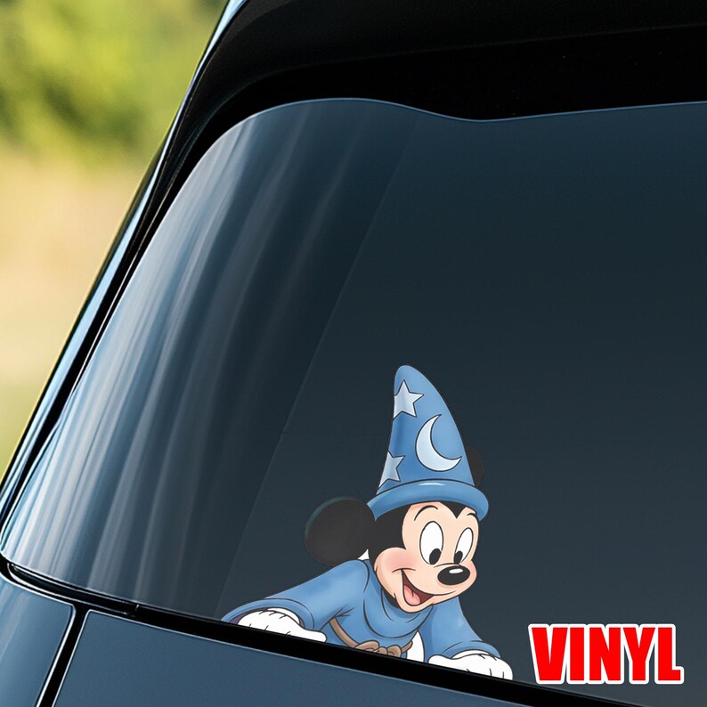 Puede incluir: Una calcoman&iacute;a de vinilo azul con Mickey Mouse vestido de hechicero, con un sombrero adornado con estrellas y una luna creciente. La palabra "VINYL" est&aacute; impresa en rojo. Dise&ntilde;ado para su aplicaci&oacute;n en la ventana de un coche.