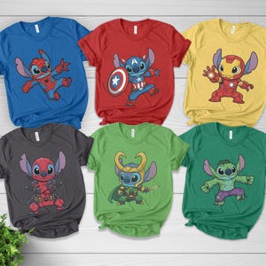 May include: Six colorful t-shirts featuring cartoon character Stitch in various superhero costumes. The shirts are blue, red, yellow, gray, green, and dark green. Each shirt has a different superhero theme, including Spider-Man, Captain America, Iron Man, Deadpool, Loki, and Hulk.